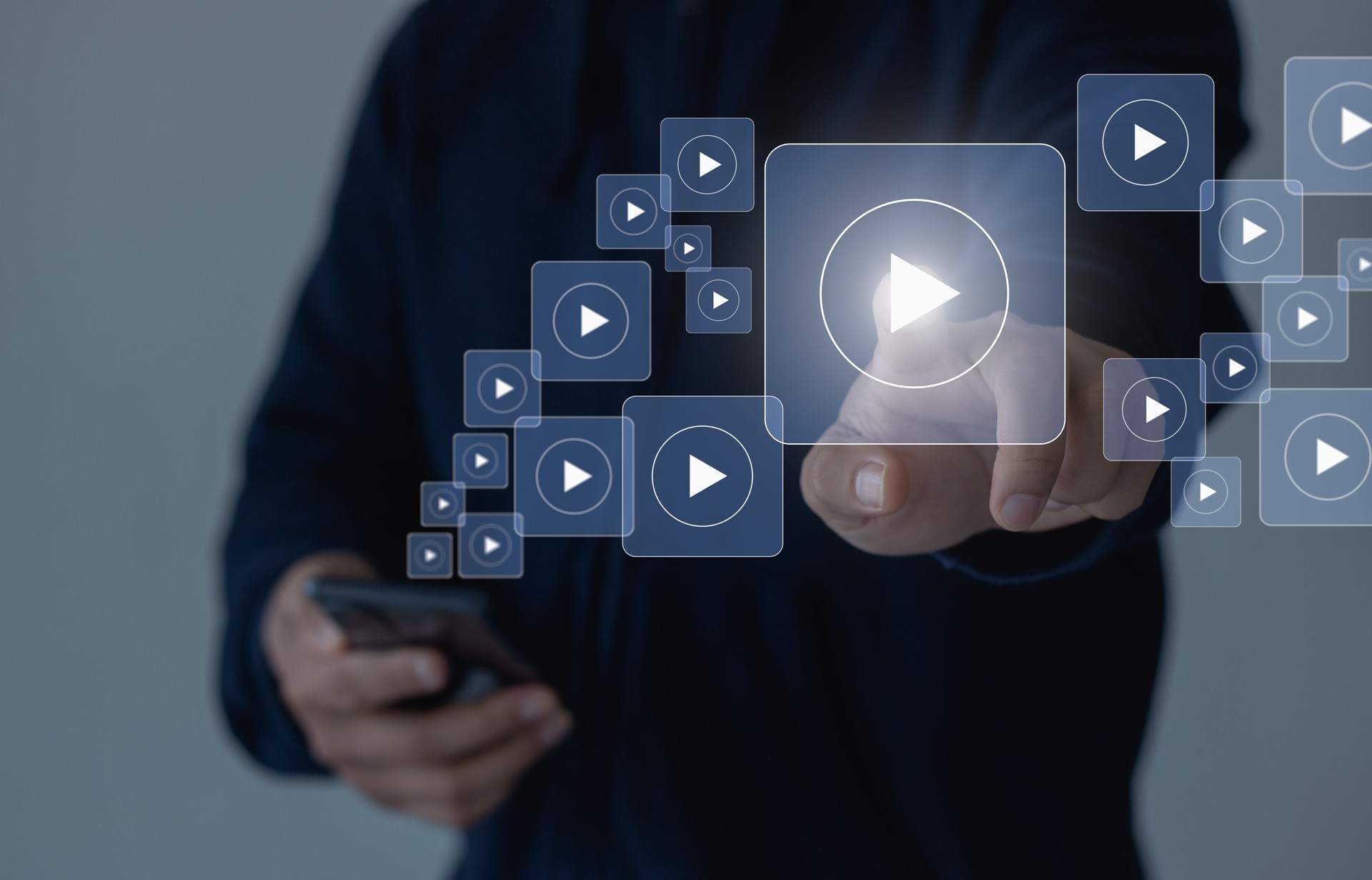 Online movie stream with mobile phone. Video on demand technology with person touching play button on virtual screen to watch online VOD streaming of movie, TV on smartphone with video player service.